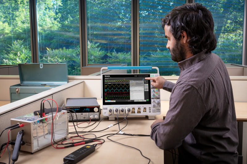 Engineer using a 4 Series B MSO connected to an AC-DC power supply to measure the power quality of the input of the supply