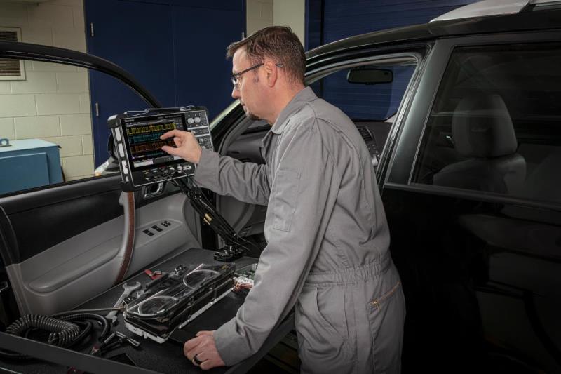 Automotive engineer debugging CAN bus using a Tektronix 2 Series Mixed Signal Oscilloscope.