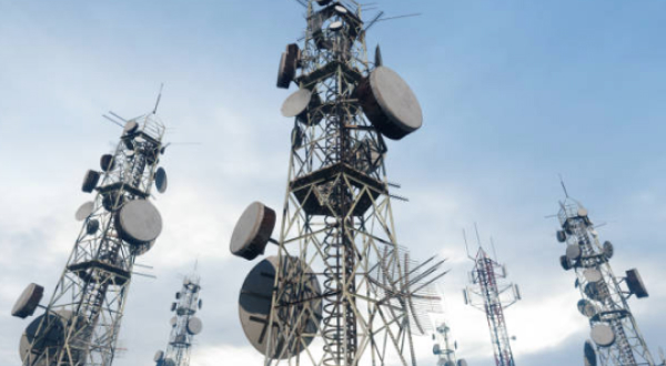 Multiple telecommunications towers with various antennas and dishes
