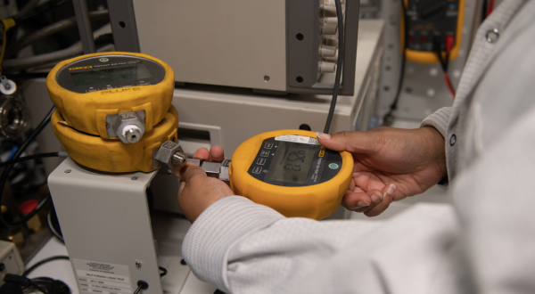 A technician calibrating a digital pressure gauge