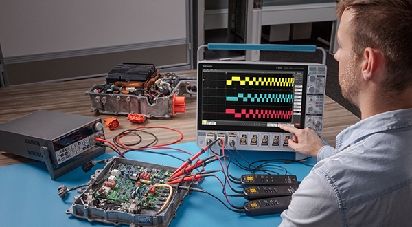 Engineer making 3-phase measurements on an EV power inverter