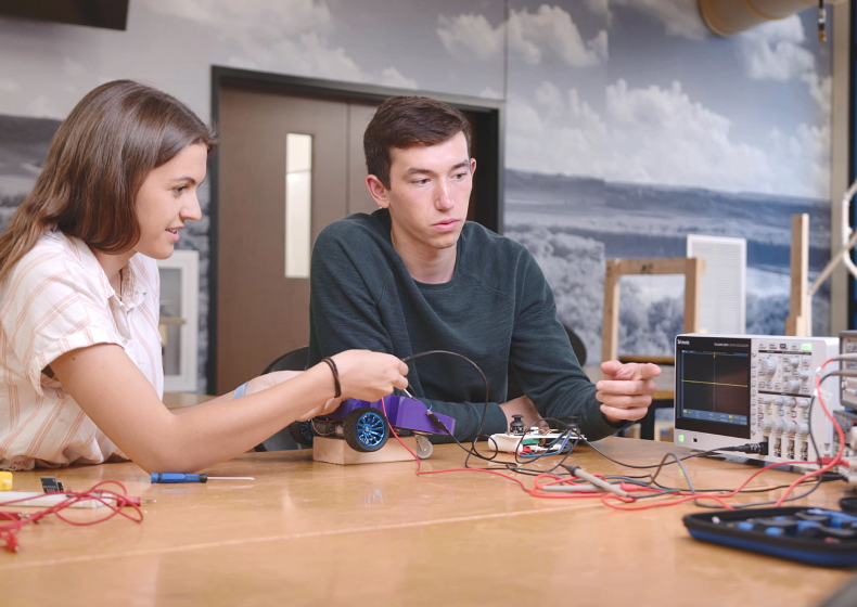 two university of mary students viewing data on an oscilloscope